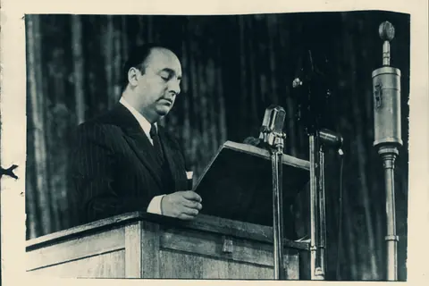 Pablo Neruda leyendo un discurso ante un micrófono