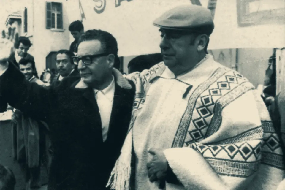 Salvador Allende y Pablo Neruda, con poncho, saludando a una multitud
